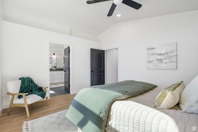 bedroom featuring vaulted ceiling, baseboards, light wood finished floors, a ceiling fan, and ensuite bathroom