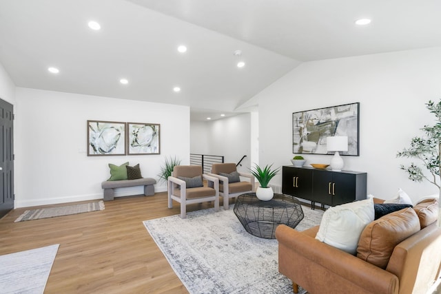 living room featuring baseboards, lofted ceiling, light wood-style flooring, and recessed lighting