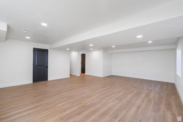 finished below grade area with recessed lighting, visible vents, baseboards, and light wood-type flooring