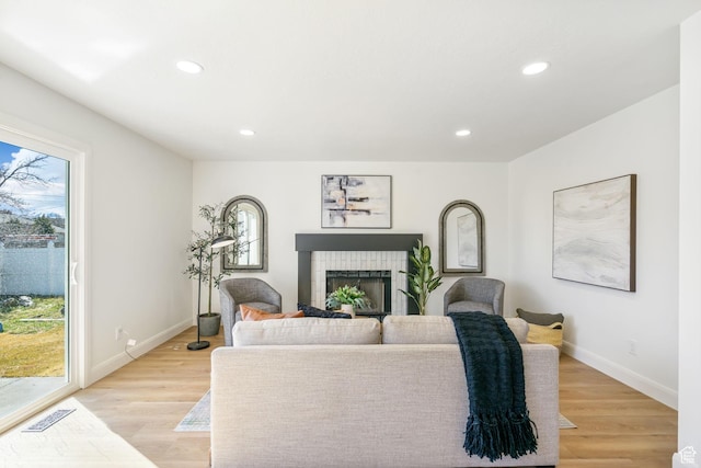 living room featuring plenty of natural light, a fireplace, and light wood-type flooring