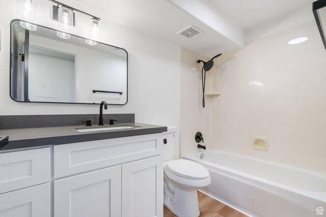 full bath featuring visible vents, toilet, wood finished floors, vanity, and shower / bathtub combination