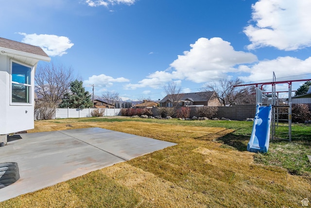 view of yard with a patio, a fenced backyard, and a playground