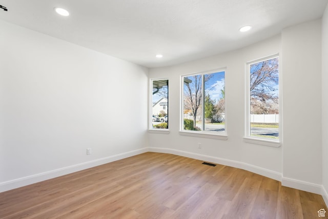 unfurnished room with light wood finished floors, baseboards, visible vents, and recessed lighting