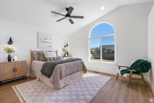 bedroom with baseboards, lofted ceiling, wood finished floors, and a ceiling fan