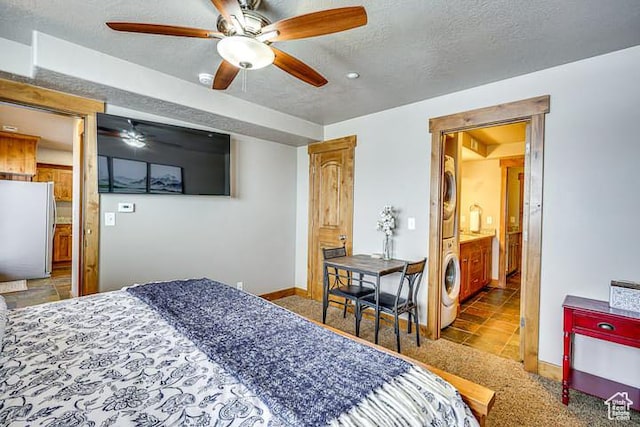 3518 N Moose Hollow Dr, Eden, UT 84310 - bedroom featuring freestanding refrigerator, stacked washing maching and dryer, a textured ceiling, baseboards, and carpet
