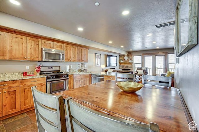 3518 N Moose Hollow Dr, Eden, UT 84310 - kitchen with stone finish flooring, a peninsula, stainless steel appliances, visible vents, and recessed lighting