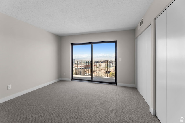 245 N Vine St W Unit 903, Salt Lake City, UT 84103 - unfurnished bedroom featuring carpet floors, baseboards, access to exterior, and a textured ceiling