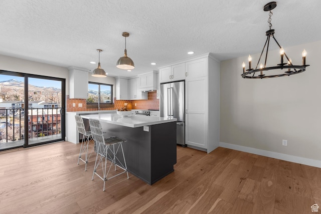 245 N Vine St W Unit 903, Salt Lake City, UT 84103 - kitchen with light wood-style flooring, backsplash, stainless steel appliances, and a chandelier