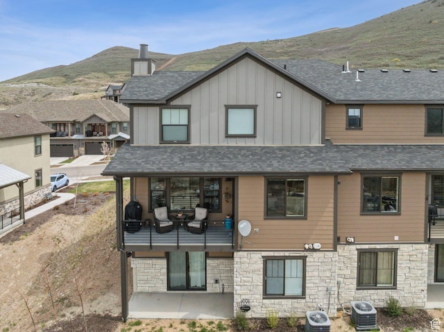 6065 N Westridge Rd, Heber City, UT 84032 - rear view of property featuring board and batten siding, a mountain view, stone siding, and cooling unit