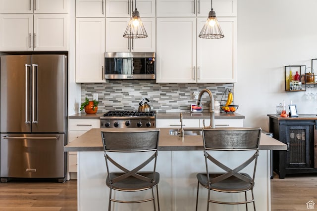 6065 N Westridge Rd, Heber City, UT 84032 - kitchen featuring white cabinets, stainless steel appliances, wood finished floors, and tasteful backsplash