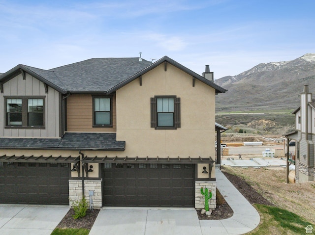 6065 N Westridge Rd, Heber City, UT 84032 - view of front of house with a shingled roof, a garage, board and batten siding, a mountain view, and a chimney