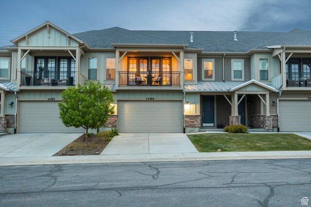 1089 W Cattail Ct, Kamas, UT 84036 - view of front of home featuring a balcony, stone siding, an attached garage, a shingled roof, and driveway