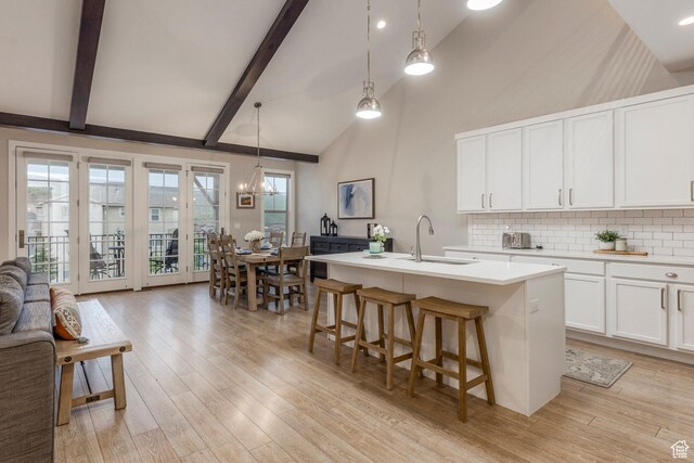 1089 W Cattail Ct, Kamas, UT 84036 - kitchen featuring a sink, backsplash, light countertops, beamed ceiling, and light wood-style floors
