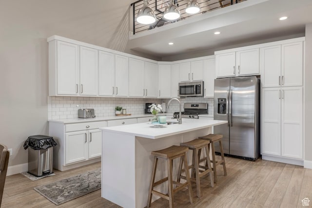 1089 W Cattail Ct, Kamas, UT 84036 - kitchen featuring appliances with stainless steel finishes, tasteful backsplash, light countertops, light wood-type flooring, and a sink
