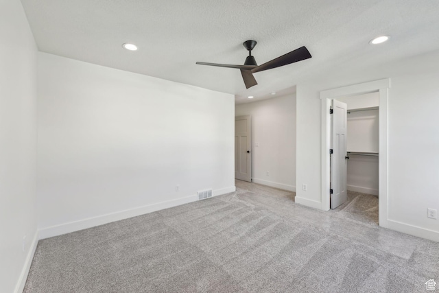 unfurnished bedroom featuring baseboards, a walk in closet, visible vents, and recessed lighting