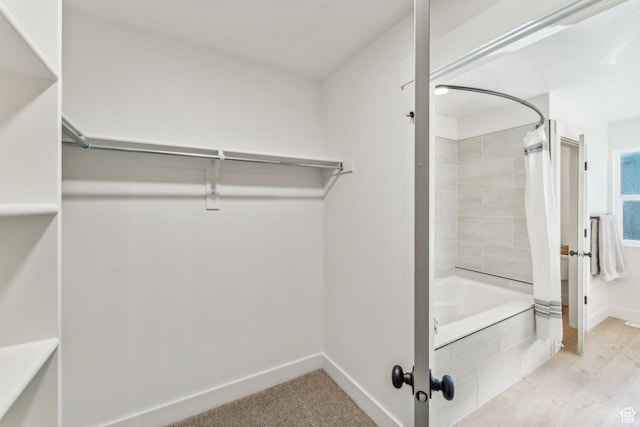 bathroom featuring baseboards and tiled shower / bath