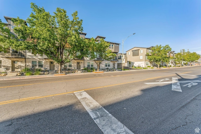 view of street featuring sidewalks, a residential view, street lighting, and curbs