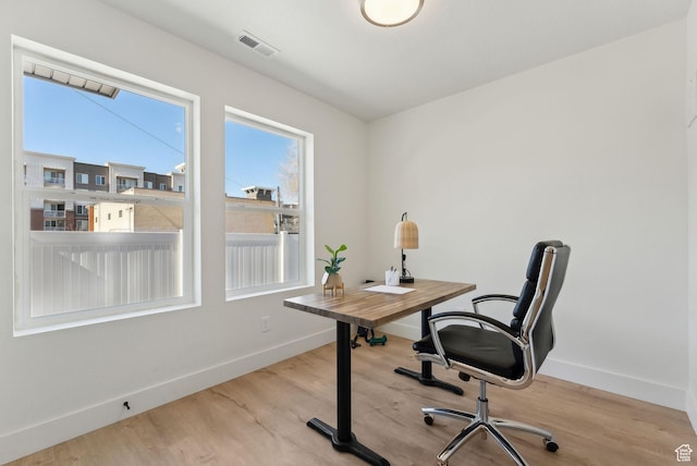 office featuring baseboards, visible vents, and wood finished floors