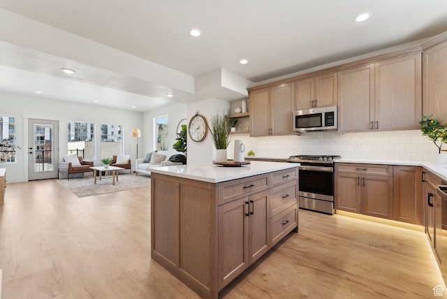 kitchen with backsplash, stainless steel appliances, and light wood-style floors