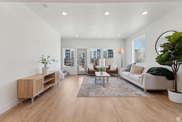 living room with baseboards, light wood-type flooring, and recessed lighting