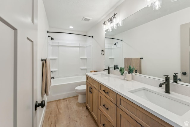 full bath featuring wood finished floors, a sink, toilet, and visible vents