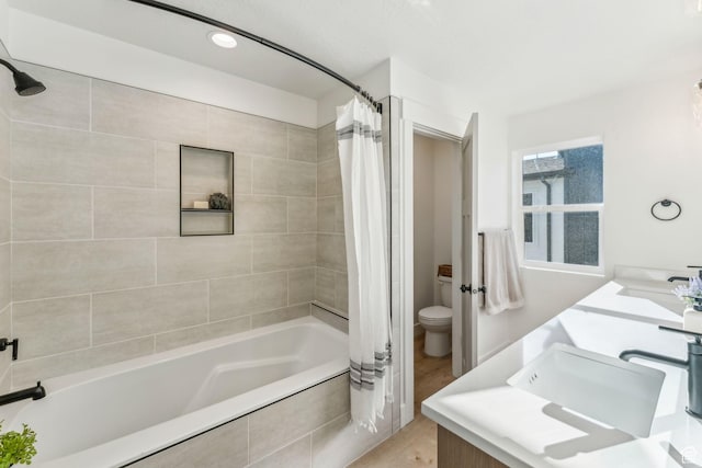 full bath featuring double vanity, toilet, a sink, and shower / bath combo
