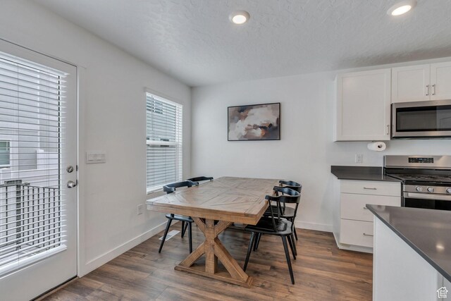 dining room with recessed lighting, a textured ceiling, baseboards, and dark wood finished floors