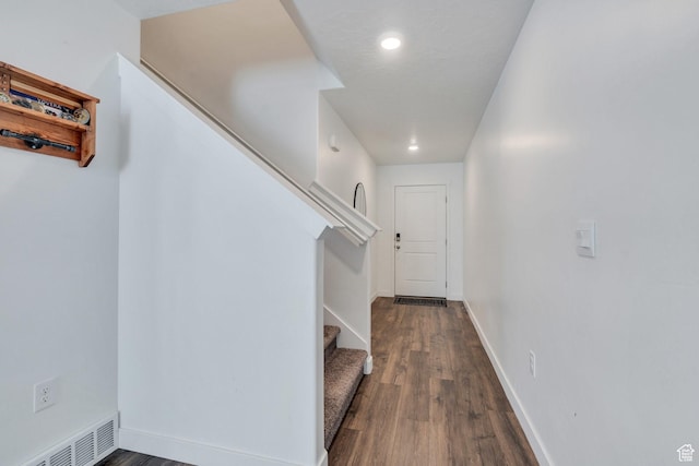 corridor with dark wood-style flooring, baseboards, stairs, and visible vents