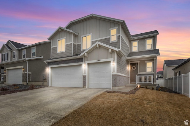 view of front of home featuring fence, an attached garage, board and batten siding, and concrete driveway