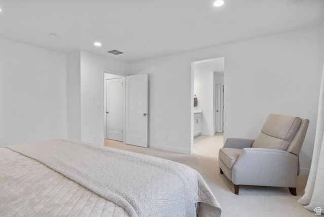 bedroom featuring visible vents, baseboards, recessed lighting, ensuite bath, and light colored carpet