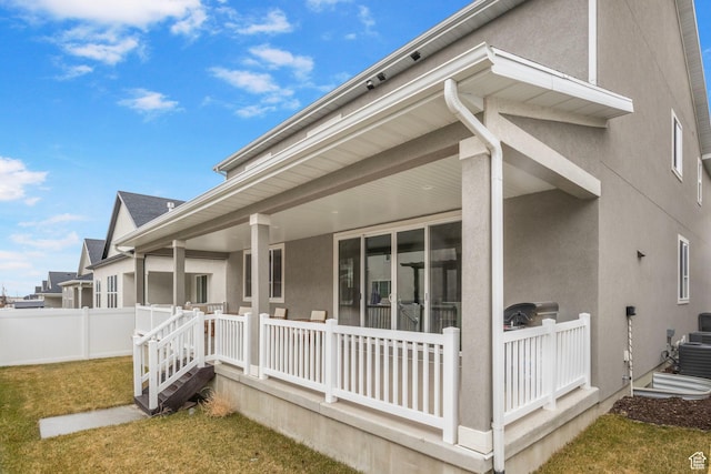 view of home's exterior featuring stucco siding, fence, and a yard