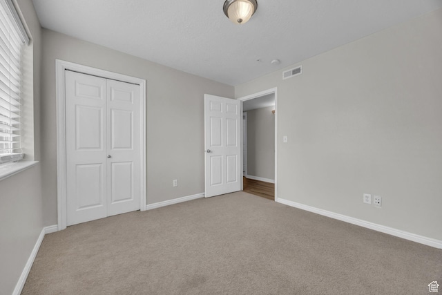 1598 Westbury Way Unit H, Lehi, UT 84043 - unfurnished bedroom featuring baseboards, visible vents, a closet, and carpet