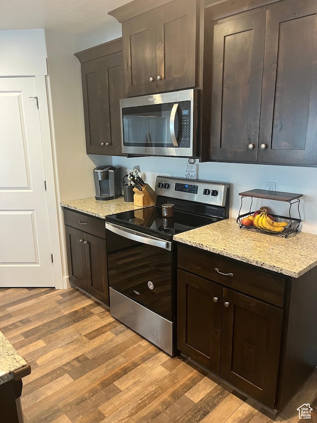 956 W 40 N, Spanish Fork, UT 84660 - kitchen featuring light wood-style flooring, light stone countertops, stainless steel appliances, and dark brown cabinets