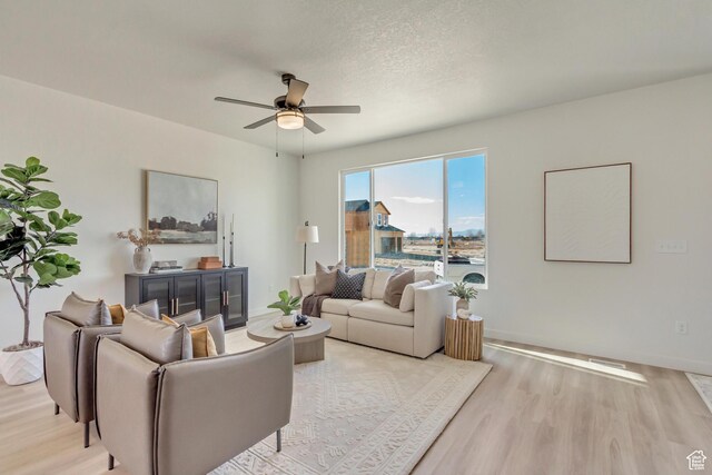 2398 E Cinder Ln, Eagle Mountain, UT 84005 - living area featuring a textured ceiling, baseboards, ceiling fan, and light wood-type flooring