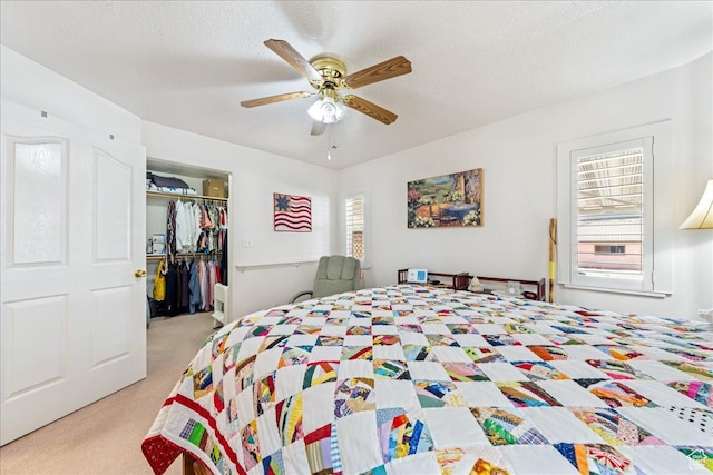 180 N 1100 E Unit 24, Washington, UT 84780 - bedroom with a closet, a walk in closet, a textured ceiling, ceiling fan, and carpet