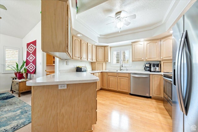 180 N 1100 E Unit 24, Washington, UT 84780 - kitchen with plenty of natural light, a peninsula, light brown cabinets, and stainless steel appliances