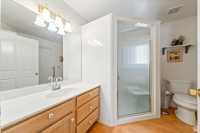 180 N 1100 E Unit 24, Washington, UT 84780 - bathroom featuring visible vents, a shower stall, toilet, wood finished floors, and vanity