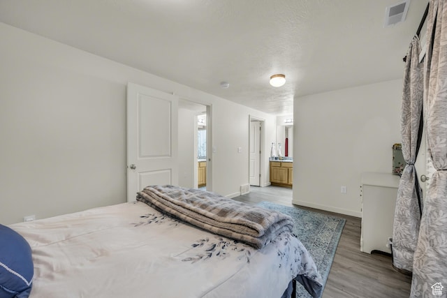5116 W Rock Butte Rd, Herriman, UT 84096 - bedroom with baseboards, ensuite bath, visible vents, and wood finished floors