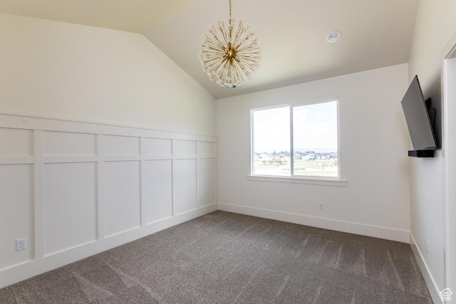 spare room with baseboards, lofted ceiling, dark carpet, and an inviting chandelier