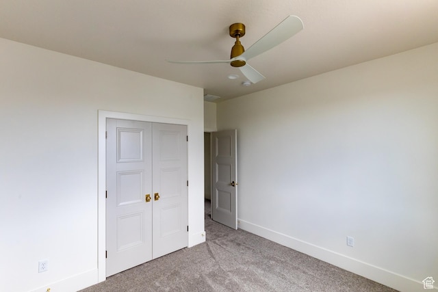 unfurnished bedroom with carpet flooring, a ceiling fan, a closet, and baseboards