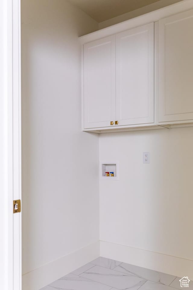 clothes washing area with marble finish floor, cabinet space, hookup for a washing machine, and baseboards