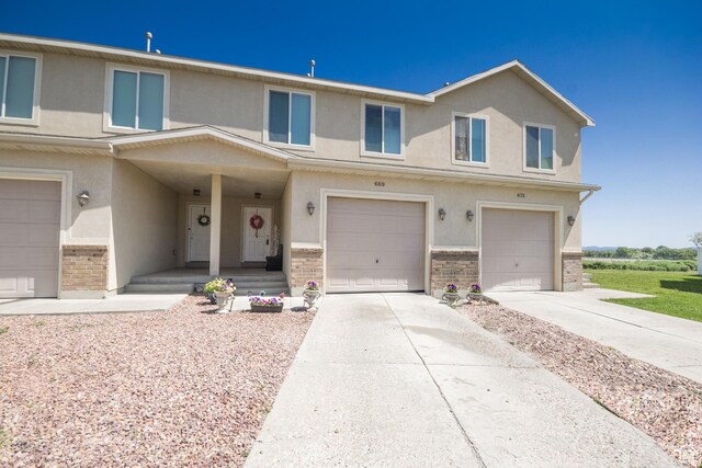 669 E 1375 S, Vernal, UT 84078 - view of property featuring brick siding, an attached garage, stucco siding, and driveway