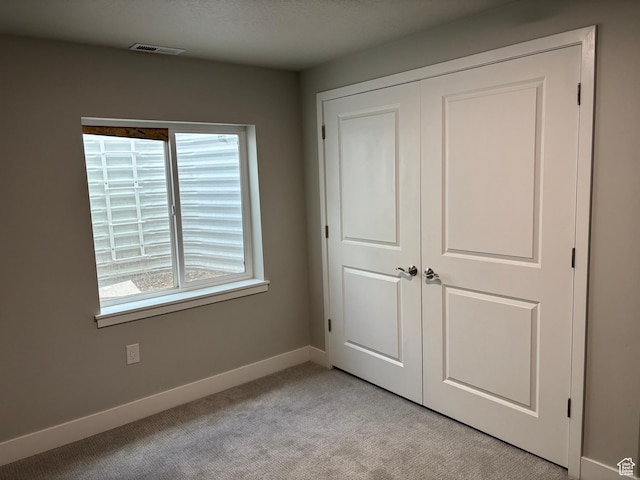 12038 S Middle Teton Dr Unit 134, Herriman, UT 84096 - unfurnished bedroom with light colored carpet, baseboards, and a closet