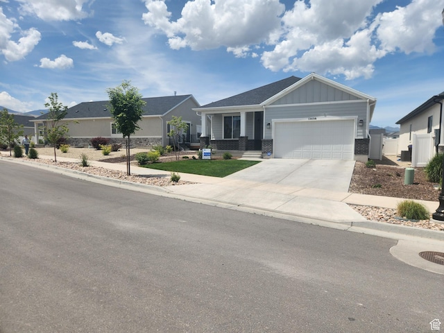 12038 S Middle Teton Dr Unit 134, Herriman, UT 84096 - view of front of house featuring an attached garage, driveway, board and batten siding, and brick siding