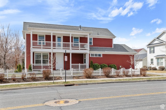 view of front facade with a balcony, a fenced front yard, and a porch