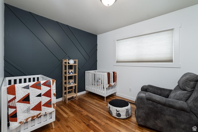 bedroom with baseboards and wood finished floors