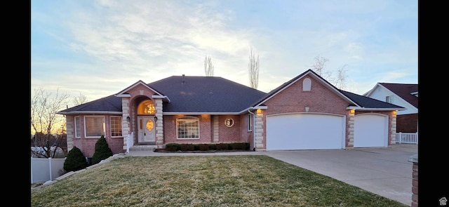 ranch-style house featuring a front yard, concrete driveway, fence, and an attached garage