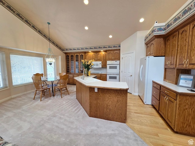 362 S Glen Cir, Fruit Heights, UT 84037 - kitchen with vaulted ceiling, a sink, brown cabinets, white appliances, and decorative light fixtures