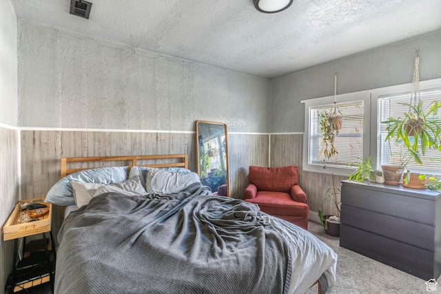 629 S 400 E, Salt Lake City, UT 84111 - bedroom featuring carpet flooring, a wainscoted wall, wood walls, and a textured ceiling