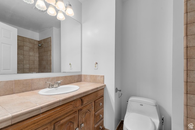 full bath featuring visible vents, a chandelier, toilet, vanity, and tiled shower